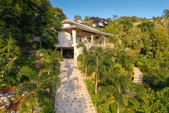 Private stone driveway and covered parking in the 1,400 m² landscaped garden