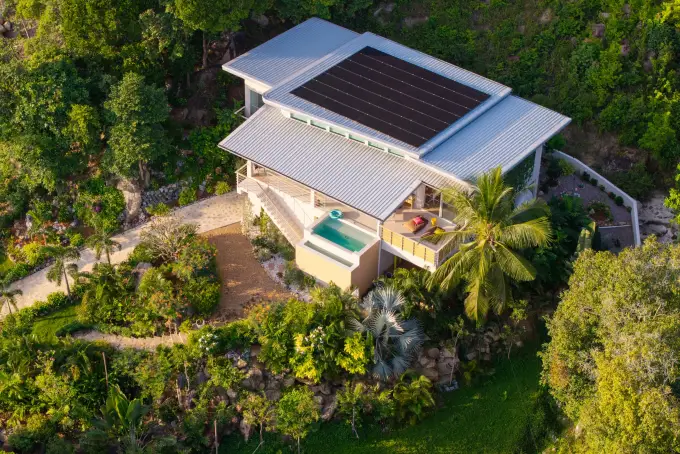 Aerial view showing the solar roof array, plunge pool, and tropical grounds